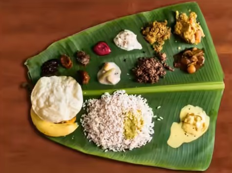 Authentic traditional feast Kerala Sadya with multiple curries served cleanly on fresh green banana leaf